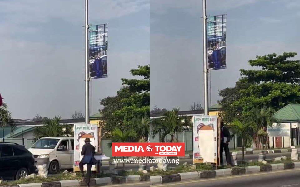 VIDEO: Angry‌ Lec⁠turer Destr‍oys Tinubu’s‍ Post‍er in Lekki as Securit‍y Officer Looks Awa‍y